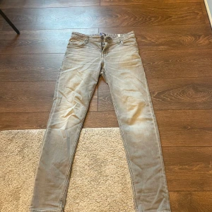 Slim Glenn - Slim Glenn jeans från Jack and Jones. Grå färg. Storlek 170 för 15 åringar. Använda i kanske 4 månader men sluta använda pga hade för stora lår. Går att diskutera priset och fråga gärna om mer bilder om ni undrar.