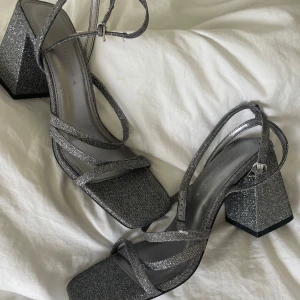 Glittriga klackar  - Oanvända silverglittriga klackar från pull & bear. Klacken är ca. 8 cm hög🪩