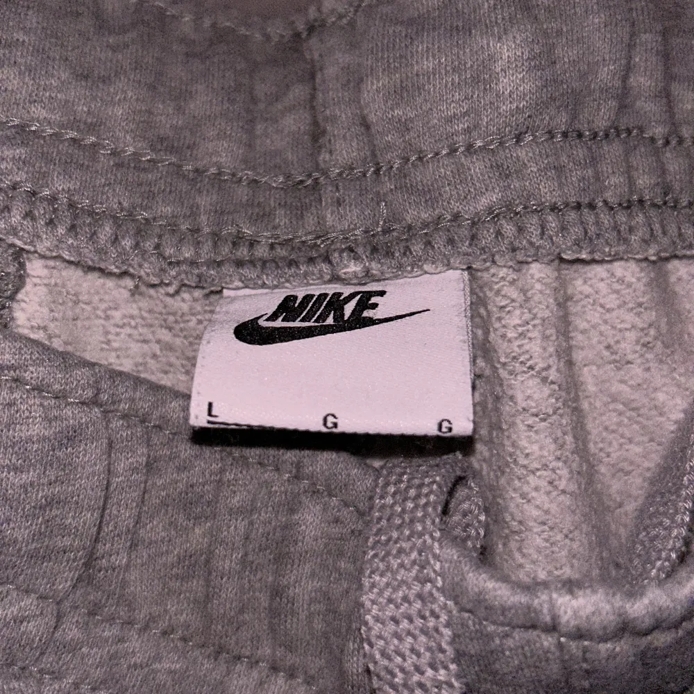 Säljer ett par grå mjukisbyxor från Nike i storlek L. De är superbekväma med elastisk midja och dragsko för perfekt passform. Byxorna har en bakficka och det klassiska Nike-loggan på framsidan. (Nypris: 849kr) Priset ej huget i sten!. Jeans & Byxor.