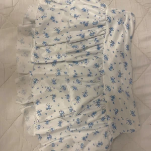 blommig kjol - Säljer denna söta kjol för det kommer inte till användning använda 1-2 gånger, den har inbyggda shorts i sig💕