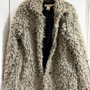 Jacka i fuskpäls från H&M Logg i storlek 40 - Fuskpäls jacka i storlek 40 i polyester. Använd Max 2 gånger. 