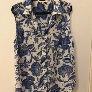 En vit blå kort ärmad blus - Den är ungefär helt ny den är liten därför sålde jag den.
