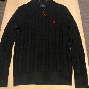 Marinblå stickad tröja från Ralph Lauren - Säljer en snygg svart stickad tröja från Ralph Lauren. Nästan aldrig använd då den är för stor. Den är L men passar M. Väldigt bra skick