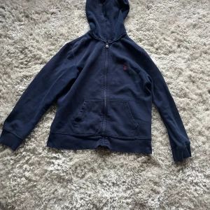 Mörkblå hoodie från Ralph Lauren - Säljer en bekväm mörkblå hoodie från Ralph Lauren som e dunder snygg. Perfa för kyliga dagar och passar till nästan allt. Hör av dig om du är intresserad🔥Priset går att förhandla