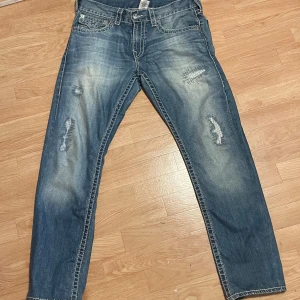 True Religion jeans - Low waisted jeans, 95cm över midjan. Har köpt från en kompis men jag själv har bara använt dom ett var gånger. Har en fläck på höger ben.