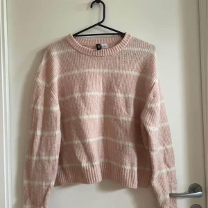 Mysig långärmad tröja  - En mysig stickad tröja. Den är långärmad med rosa och vita ränder.
