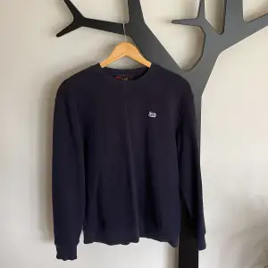 Marinblå crewneck ifrån märket Lee i storlek M, men passar S. Plagget är sparsamt använt under ett fåtal tillfällen. Nypris 500kr.