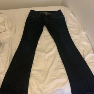 Blå jeans - Blå utsvängda, LÅG midjade jeans med snygga detaljer. 