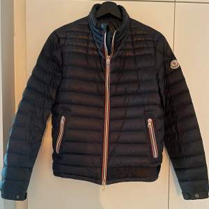 Moncler modell, Daniel short down. I absolut nyskick dock har den lagats hos skräddare längst ner på jackans vänstra sida då det blev en reva i tyget. Stl 1= Small 