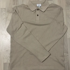 !!NY!! Beige pikétröja från H&M - Säljer en stilren beige pikétröja från H&M. Tröjan har långa ärmar och har en riktigt snygg krage med knappar. Inköpt för 229, helt oanvänd. Storlek S