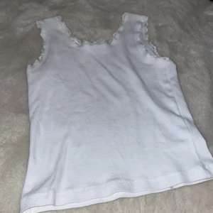 Vit linne från lager 157 - Säljer ett vitt linne från lager 157 med fina spetsdetaljer längs kanterna. Perfekt för varma dagar eller som ett basplagg i garderoben. Normal pris 50kr