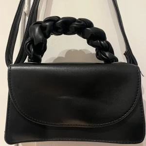 Svart axelväska med flätat handtag - Söt väska med flätat handtag, köpt på Ullared men aldrig använd 🖤