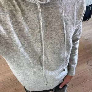 Merinoull hoodie - Säljer en supermysig grå merinoull hoodie som är perfekt för kyliga dagar. Som aldrig har varit buren, tröjan är helt ny och är i sprillans nytt skick! Den har en klassisk design med dragsko i huvan och ribbade muddar vid ärmslut och nederkant. Passar både till vardags och för en avslappnad stil. Perfekt för höst och vinter! Skriv gärna vid funderingar, tröjan passar 160-170cm.