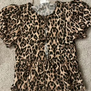 Leopardmönstrad topp från Gina Tricot - Snygg leopardmönstrad topp från Gina Tricot med korta ärmar och knytning framtill. Har inga defekter och är bara använd max 4 gånger. original pris 229kr. Är öppen för prisförslag💞