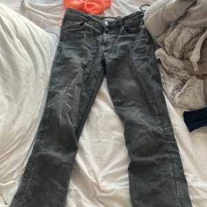Grå jeans från Gina Tricot - Snygga grå jeans från Gina Tricot med en klassisk femficksdesign. De har en knapp och dragkedja framtill . Perfekta för en avslappnad stil.