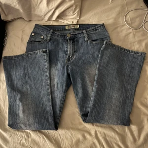 Blå vintage lågmidjade jeans. - Snygga blå lågmidjade bootcut jeans från okänt märke. Kan tyvärr inte visa bilder med dem på eftersom de är alltför små för mig i längden. Skulle gissa att de passar någon som är runt 140-150. Skulle säga att de är 34/36 i strl.