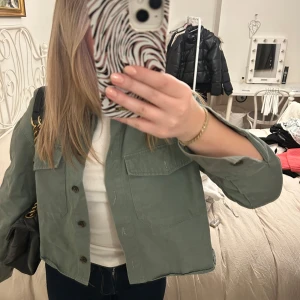 Grön jacka från Vero Moda - Snygg grön jacka från Vero Moda med knappar framtill och två bröstfickor. Perfekt för en avslappnad stil. Jackan har en klassisk krage och är i en skön bomullsmix.