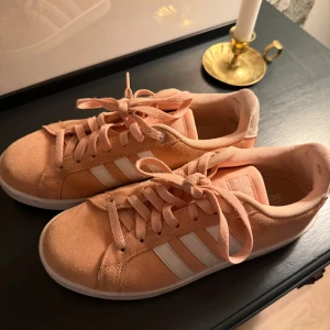 Rosa sneakers från Adidas - Snygga rosa sneakers från Adidas med klassiska vita ränder på sidan.  I stl 39 använda ett få tal gånger men säljer då de är för små🥹