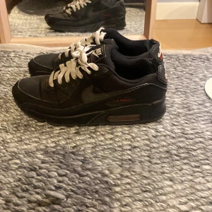 Svarta Nike Air Max sneakers - Säljer ett par svarta Nike Air Max sneakers med vit snörning. Skorna har en klassisk design med synlig luftdämpning i sulan och Nike-logga på plösen. Skick 6/10