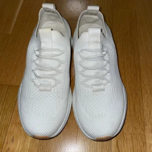 Vita sneakers från Ellos, stl 36 - Snygga vita sneakers från Ellos med stickad ovandel och elastisk snörning. Lätta och luftiga. 