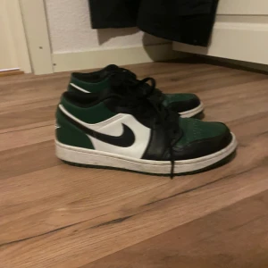 Nike Air Jordans i grönt och svart - Snygga Nike Air Jordans i grönt, svart och vitt. Skorna har en klassisk design med snörning och den ikoniska Nike-loggan på sidan. Perfekta för en sportig look.Priset kan diskuteras vid snabb köp