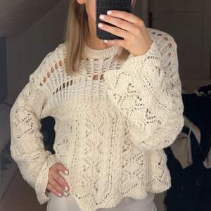 Säljer en snygg beige stickad tröja med unikt mönster och lång ärm. Perfekt för lager-på-lager och ger en bohemisk touch till din outfit. Passar bra till både jeans och kjol.