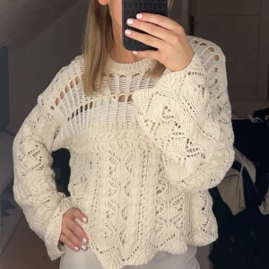 Beige stickad tröja - Säljer en snygg beige stickad tröja med unikt mönster och lång ärm. Perfekt för lager-på-lager och ger en bohemisk touch till din outfit. Passar bra till både jeans och kjol.