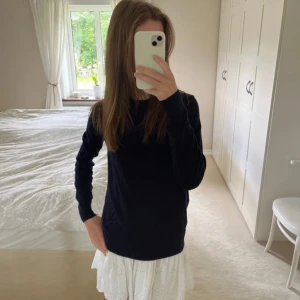 Svart långärmad stickad tröja - Säljer en stilren svart långärmad tröja. Perfekt för kyligare dagar och lätt att matcha med olika outfits. Tröjan har en klassisk design med rund hals och är tillverkad i ett mjukt material från arket, finstickad