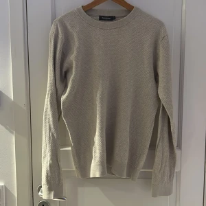 Beige bomullströja - Säljer en stilren beige tröja i 100% bomull. Tröjan har en klassisk rund hals och långa ärmar, perfekt för en avslappnad look. Passar bra till jeans eller chinos.