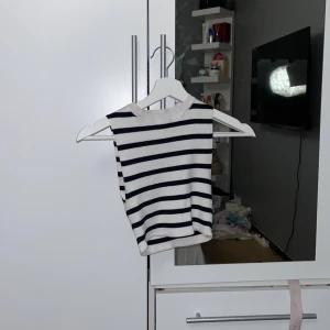 Randig ärmlös topp från Zara - Säljer en stilren randig topp från Zara i svart och vit. Den är ärmlös och har en ribbad struktur som ger en snygg passform. Perfekt för en avslappnad look.