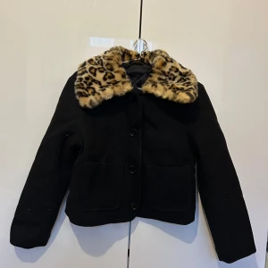 Kort kappa från Other stories med fuskpälskrage i leopard - En kort svart kappa med fuskpälskrage i leopard från & Other stories 