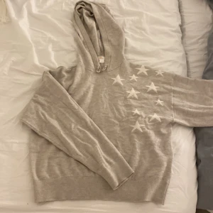 hoodie med stjärnor - Säljer en mysig beige hoodie med vita stjärnor på framsidan och en stor stjärna på baksidan. Materialet är magiskt 💕. 