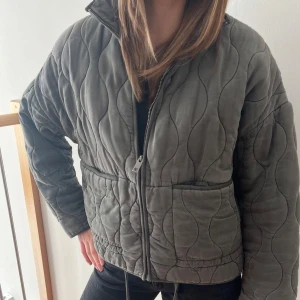 Grå quiltad jacka - Pris kan diskuteras vid snabb affär! Snygg grå quiltad jacka med dragkedja framtill. Jackan har en normal passform och långa ärmar. Fint skick, använd men köptes efter sommaren så inte haft den så länge. Nypris 859kr