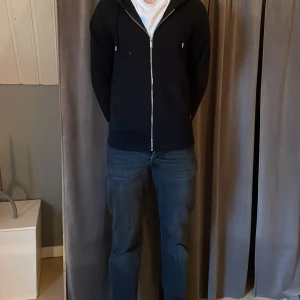 Svart hoodie med dragkedja - Snygg svart hoodie med dragkedja och huva från Jack & Jones . Säljer pga för liten 