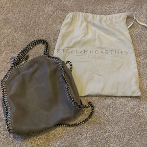 Stella McCartney väska i bra skick! - Säljer min gamla favoirt väska från Stella McCartney som är i fint skick! Det är en Small Falabella Grey bag som rymmer det mesta! Perfekt till skolan eller fest💕Köpte väskan via Affordable Luxury 2020 men har inte använt den på 3 år så det är dags för ett nytt hem för väskan😅Har kvitto och äkthetsbevis, samt dustbag ingår i köpet! Nypris 9000/1000kr! Frakt ingår inte❤️