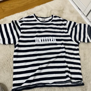 Randig T-shirt  - Vit svart randig T-shirt med tryck. Aldrig använd, är som ny. Storlek xxs men passar som xs eller s. Köpt från NA-KD. Köpte för ungefär 150 säljer för 100