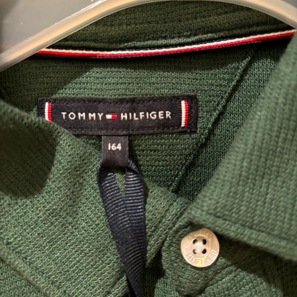 Grön skjorta från Tommy Hilfiger. passformen är normal. Knappar och krage finns framtill. På bröstet är märkets klassiska logga. Denna skjorta är lika snygg knäppt som uppknäppt. Skjortan är oanvänd och har lapparna kvar.. Skjortor.