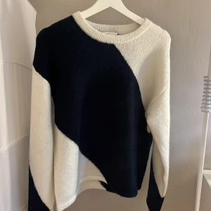 Randig tröja från Gina  - Snygg tröja från Gina Tricot i svart och vitt med ett unikt geometriskt mönster. Tröjan har en rund halsringning och långa ärmar, perfekt för en stilren look. Passar bra till både jeans och kjol. Den är aldrig använd och aldrig tvättad men prislappen är borta. 