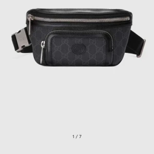 Svart midjeväska från Gucci - Snygg svart midjeväska från Gucci med diskret mönster och dragkedja. Perfekt för att bära dina nödvändigheter med stil. Väskan har en justerbar rem och en praktisk ficka framtill.
