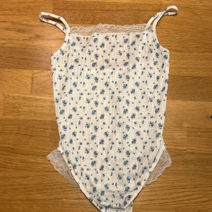 Blommig spets-body från ASOS  - Denna är helt i nyskick och har fortfarande skyddsplasten kvar! Justerbara axelband!