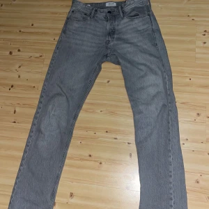 Grå jeans från Levi's - Snygga grå jeans från Jack n Jones  med klassisk femficksdesign och knappgylf. Perfekta för en avslappnad stil med en rak passform som ger en tidlös look.