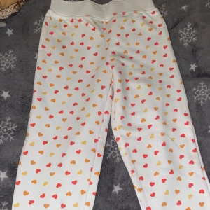 Vita byxor med hjärtmönster från Lupilu - Söta vita byxor från Lupilu . Perfekta för barn i åldern 4-6 år. Helt nya barnen har aldrig använt 