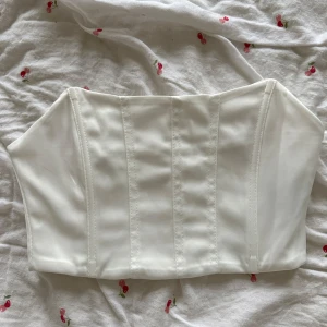 Vit korsett topp - Festtopp. Storlek S med lite stretch. Normal i storlek. Liten sminkfläck på insidan som inte syns när man har den på