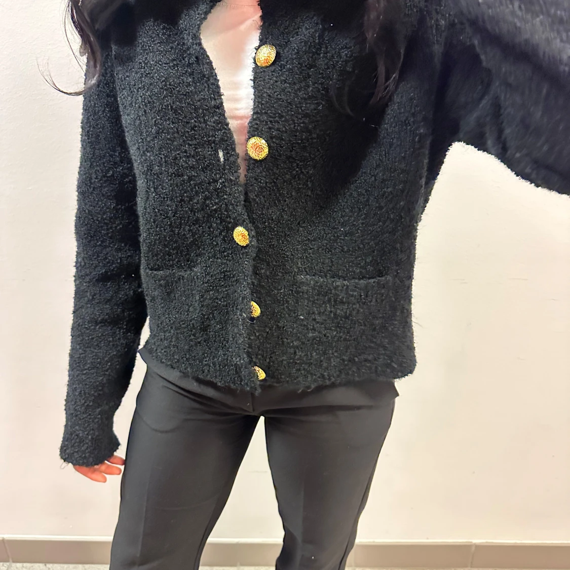 Svart stickad kofta med guldknappar