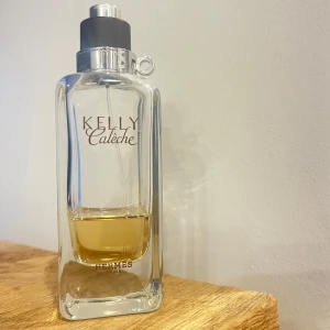 Kelly Calèche Eau de Toilette 100ml - Säljer Kelly Calèche Edt med toppnoter av grapefrukt, narcissus och liljekonvalj. Mellannoterna består av ros, mimosa och tuberos, medan basnoterna bjuder på läder och iris. Nypris: 1730kr, ungefär 1/4 av flaskan kvar!💛