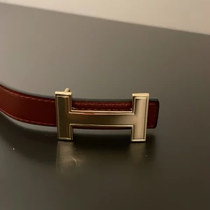 Vinrött skärp med guldfärgat spänne - Snyggt vinrött skärp i skinn 