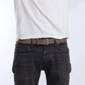 Brunt bälte i skinn - Snyggt brunt bälte i skinn med ett klassiskt spänne. Perfekt för att ge en stilren touch till din outfit. Passar bra till både jeans och chinos.