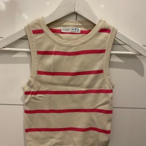 Beige och rosa randig linnetopp från Primark - Säljer en söt beige linnetopp med rosa ränder från Primark. Perfekt för varma dagar med sin ärmlösa design. Toppen är i en mjuk och bekväm bomullsmix.