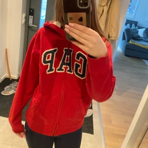 Gap hoodie  - Säljer en snygg röd Gap luvtröja med dragkedja, storlek XS (barnstorlek XXL 14-16), fint skick, köpt på Plick