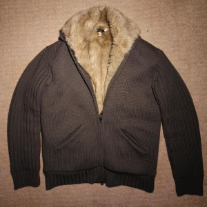 Päls fodrad cardigan Armani - Säljer en päls fodrad cardigan från märket Armani. Extremt tjock och mysig med unika detaljer perfekt till lite kallare väder. Tjock och kvalitativ päls med dubbel dragkedja vilket skapar en väldigt stilren och elegant design. Skriv vid minsta fundering!